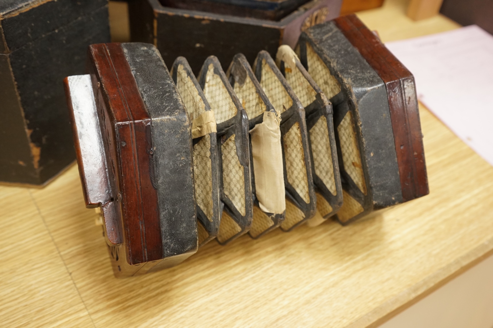 Two cased concertinas; one in mahogany with original paper label for Lachenal & Co., London, the other in rosewood (a.f.)